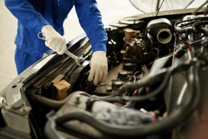 Cropped image of auto mechanic checking car engine